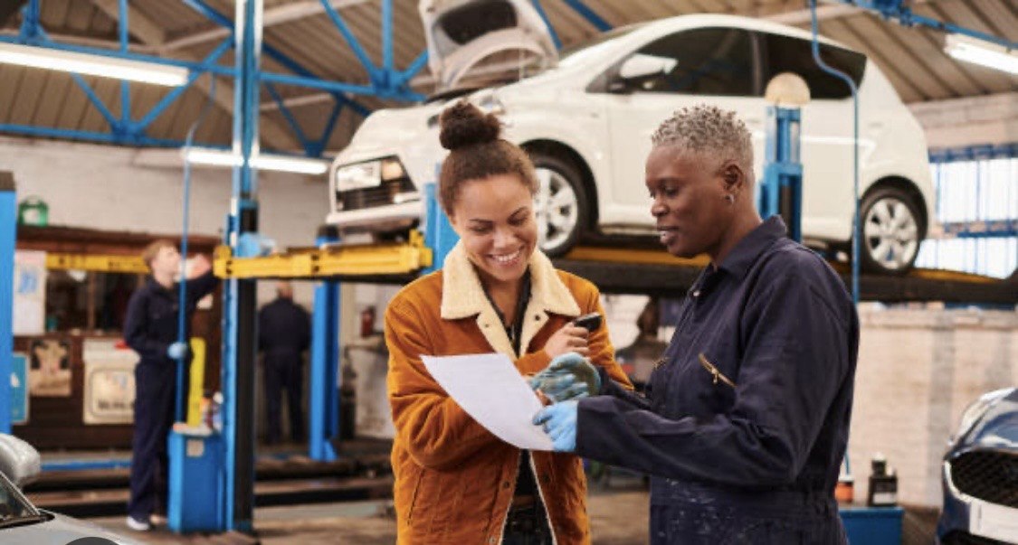 Technician reviewing repair with customer on the shop floor